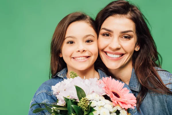 Retrato de madre e hija feliz con flores aisladas en verde - foto de stock