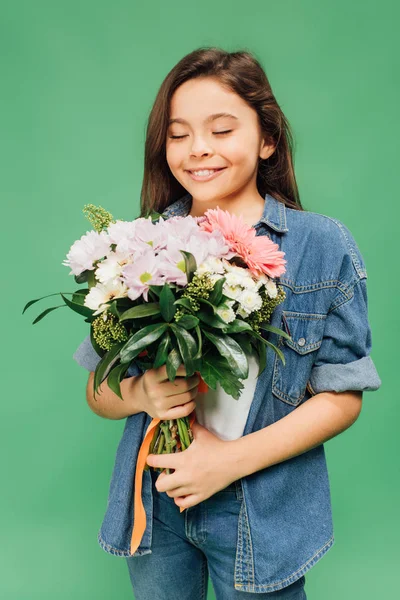 Niedliches Kind mit geschlossenen Augen hält Blumenstrauß isoliert auf grün — Stockfoto