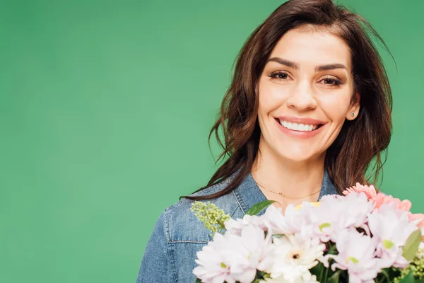 Ritratto della donna sorridente che tiene il mazzo di fiori isolato sul verde — Foto stock