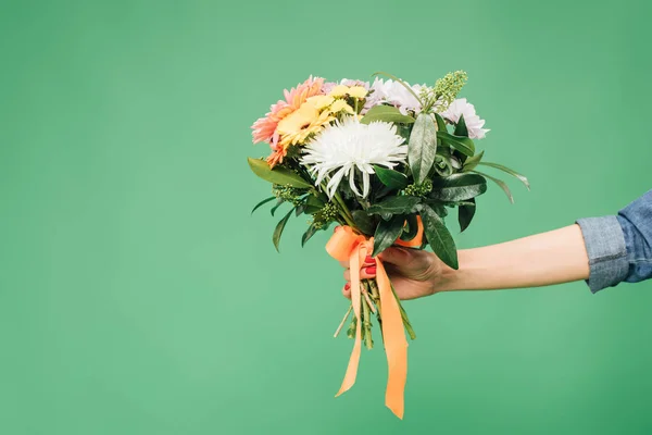 Vista ritagliata della donna che tiene mazzo di fiori isolato su verde — Foto stock