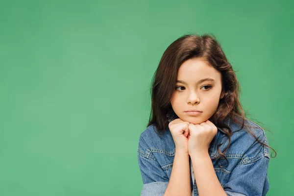 Pensive child with holding fists under chin isolated on green — Stock Photo