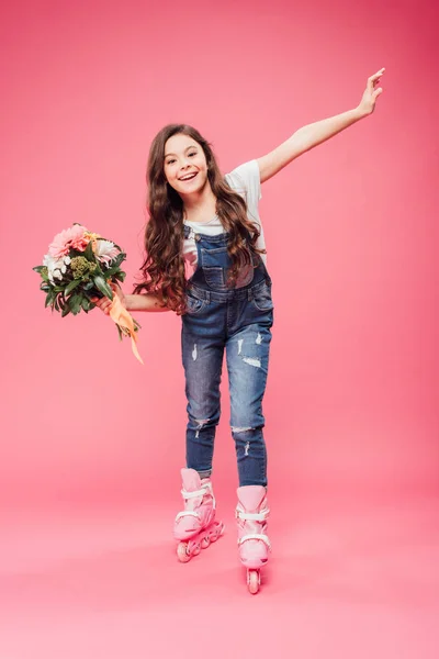 Fröhliches Kind in Rollerblades mit Blumenstrauß auf rosa Hintergrund — Stockfoto