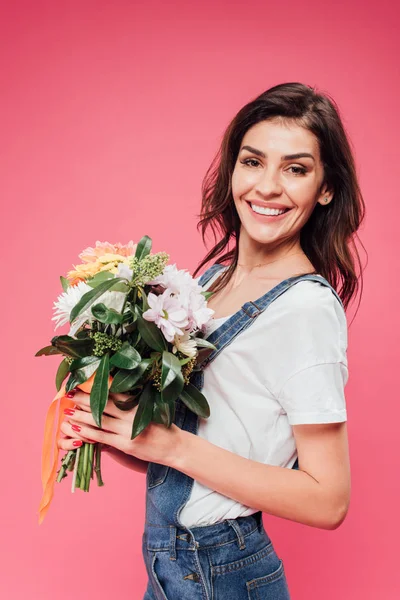 Femme souriante tenant bouquet de fleurs et regardant la caméra — Photo de stock