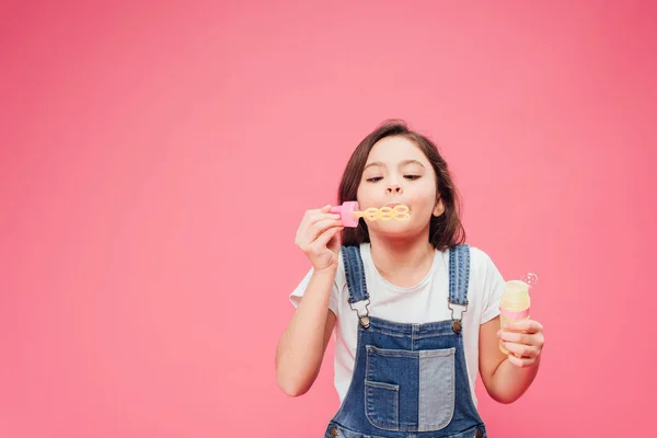 Drôle enfant soufflant bulles de savon isolé sur rose — Photo de stock