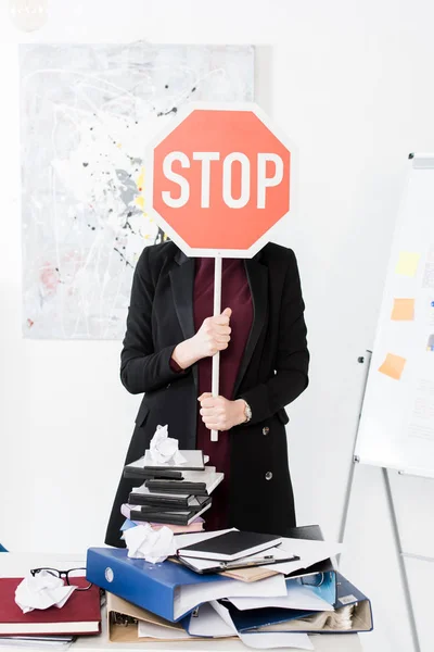 Businesswoman covering face with stop sign in office — Stock Photo