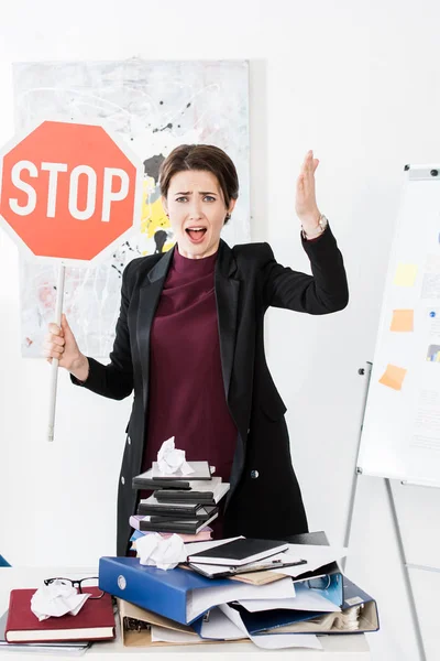 Enojado gerente sosteniendo stop signo y gritando en la oficina - foto de stock