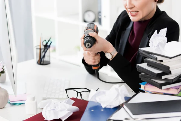 Обрізане зображення агресивної бізнес-леді, що тримає електродриль в офісі — стокове фото