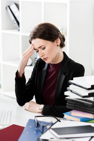 Attraktive Geschäftsfrau mit Kopfschmerzen und Berührung des Kopfes im Büro — Stockfoto