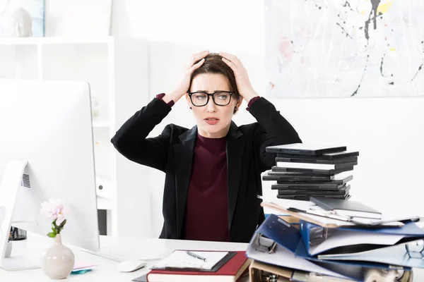 Sad tired attractive businesswoman touching head in office — Stock Photo