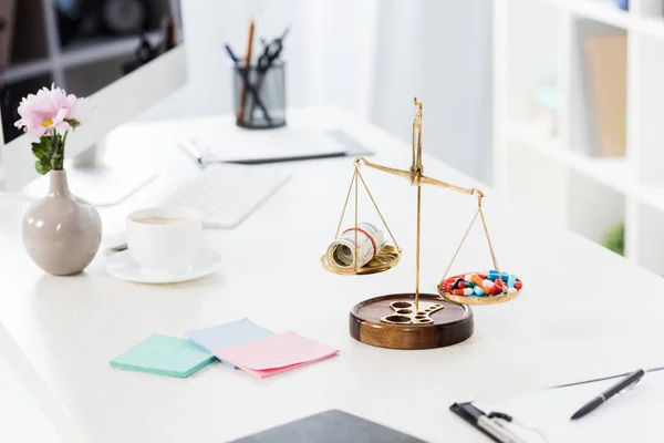 Justice scales with money and drugs on table in business office — Stock Photo