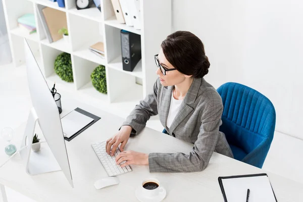 Hochwinkel-Ansicht attraktiver Geschäftsfrau mit Computer am Tisch im Büro — Stockfoto