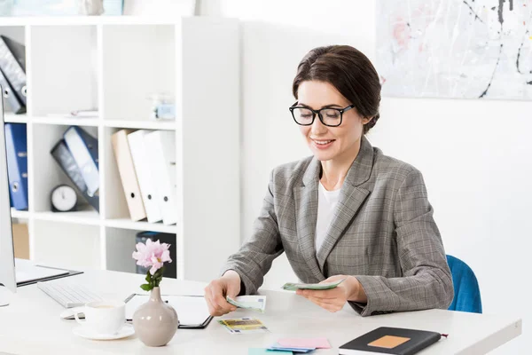 Attraktive Geschäftsfrau beim Zählen von Euro-Banknoten im Amt — Stockfoto