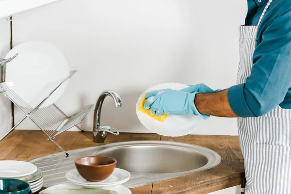 Imagen recortada de hombre maduro lavando platos en la cocina - foto de stock