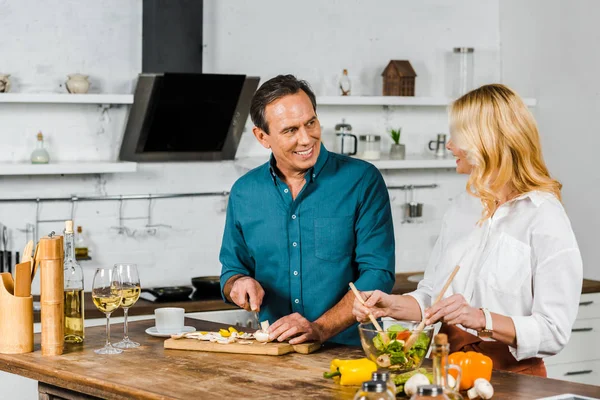 Mature femme et mari cuisine salade ensemble dans la cuisine — Photo de stock