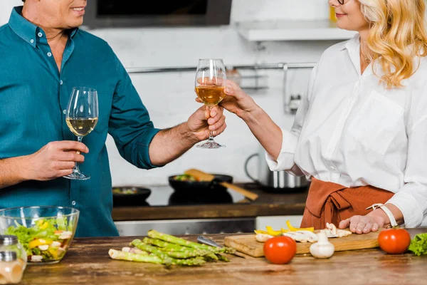 Image recadrée de mari mature donnant un verre de vin à la femme dans la cuisine — Photo de stock