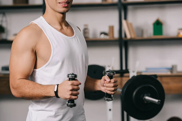 Vista recortada del hombre bi-racial muscular ejercitando con pesas - foto de stock