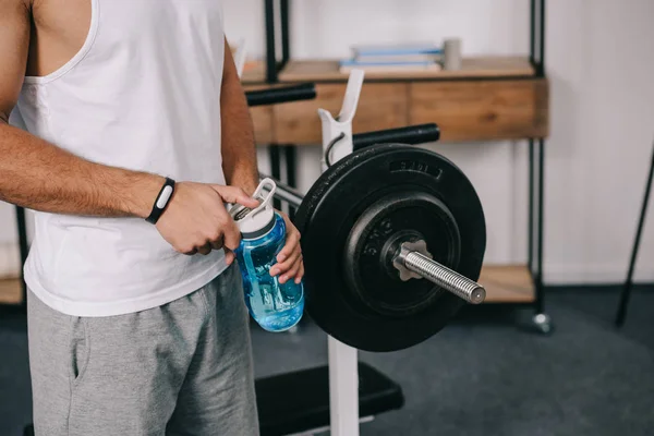 Vista recortada del hombre sosteniendo botella deportiva - foto de stock