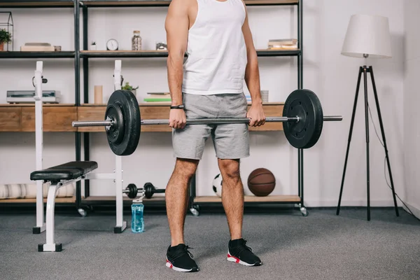 Обрезанный вид тренировки мускулистых мужчин в домашнем тренажерном зале — стоковое фото