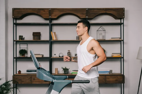 Happy muscular bi-racial man running on treadmill — Stock Photo