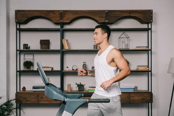 Heureux musclé bi-racial homme courir sur tapis roulant — Photo de stock