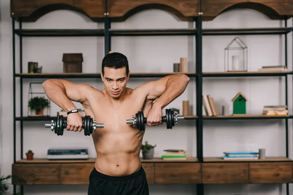 Strong bi-racial man exercising with heavy dumbbells — Stock Photo