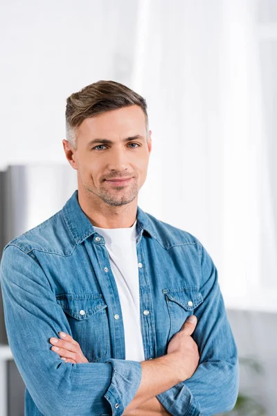 Bell'uomo con le braccia incrociate sorridente alla macchina fotografica — Foto stock