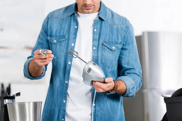Vista recortada del hombre sosteniendo mezclador de cocina y batidor - foto de stock