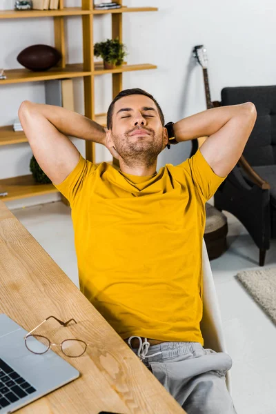 Glücklicher Mann sitzt auf Stuhl und lächelt zu Hause — Stockfoto