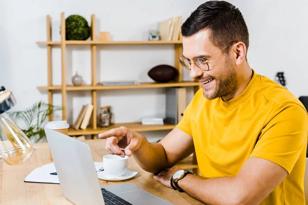 Happy man in glasses pointing with finger at laptop — Stock Photo