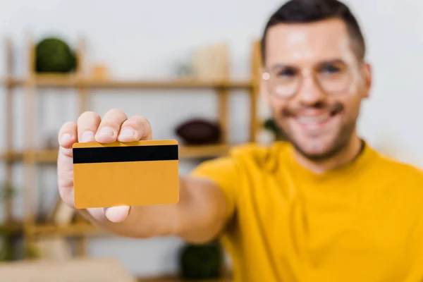 Foco selectivo de la tarjeta de crédito en la mano del hombre alegre - foto de stock