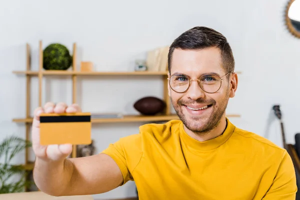 Close up de homem sorridente segurando cartão de crédito na mão — Fotografia de Stock