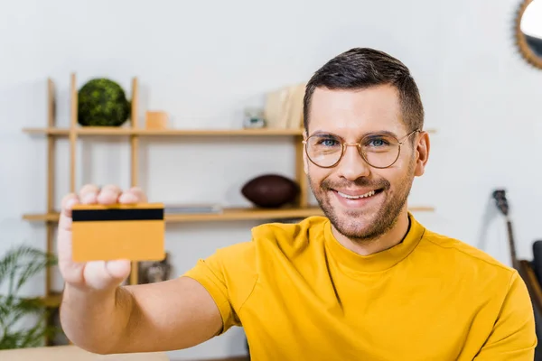 Close up of smiling man holding credit card in hand — Stock Photo