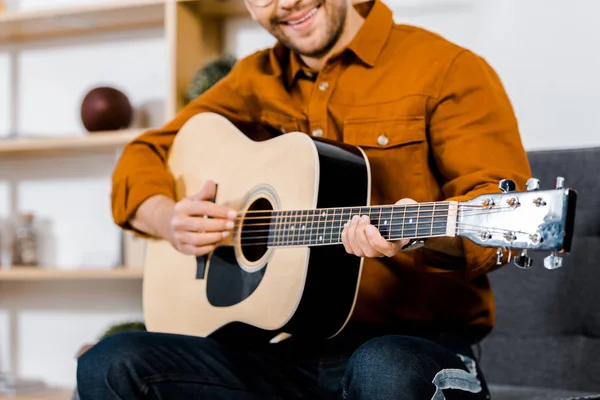 Vue recadrée de l'homme joyeux jouant de la guitare acoustique — Photo de stock