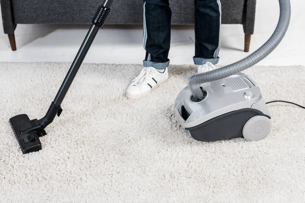 Vista recortada del hombre de pie en la sala de estar moderna cerca de hoover - foto de stock