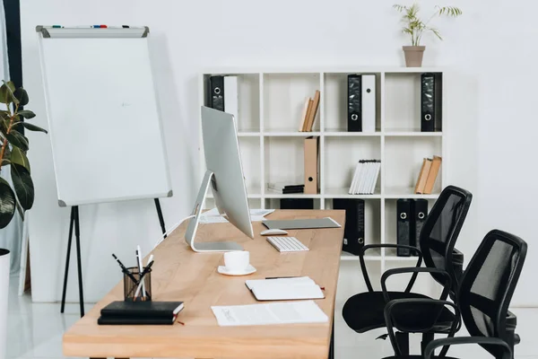 Moderno interior de oficina con computadora de escritorio y suministros de oficina, sillas y pizarra - foto de stock