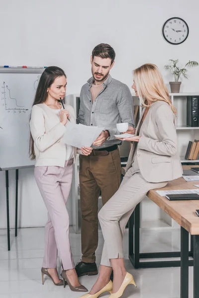 Reifer Business-Mentor bei einer Tasse Kaffee und im Gespräch mit jungen Kollegen im Büro — Stockfoto