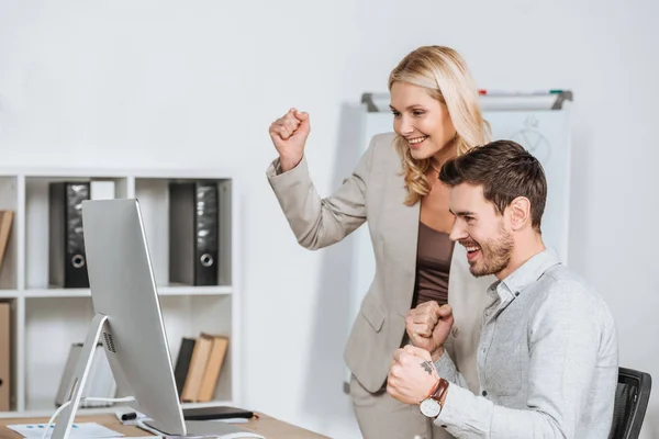 Fröhliche Geschäftsleute triumphieren und nutzen Desktop-Computer im Büro — Stockfoto