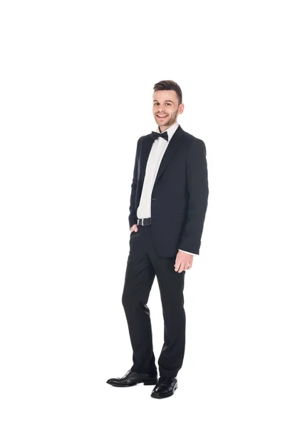 Красивий усміхнений чоловік позує в чорному смокінгу і краватка лук ізольовано на білому — стокове фото