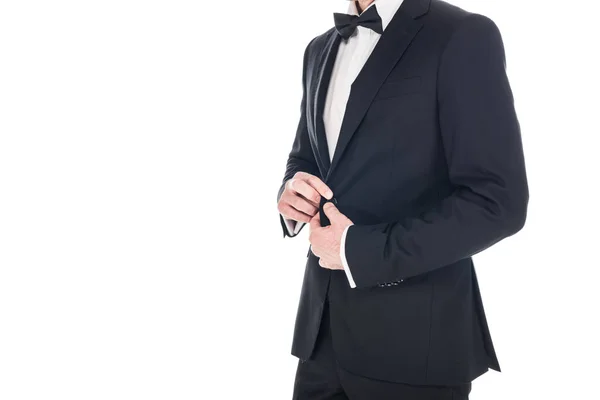 Vue recadrée de l'homme posant en smoking élégant noir et noeud papillon isolé sur blanc — Photo de stock