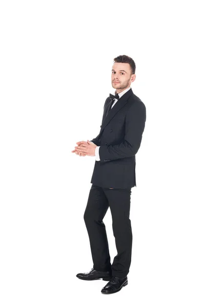 Bonito jovem posando em preto smoking e laço arco isolado no branco — Fotografia de Stock