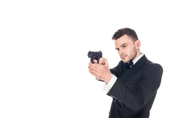 Guapo asesino en traje negro y corbata apuntando con pistola, aislado en blanco - foto de stock