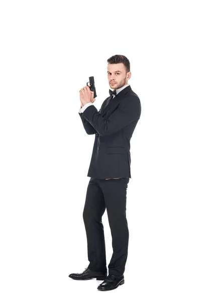 Agente secreto elegante em terno preto segurando arma, isolado em branco — Fotografia de Stock