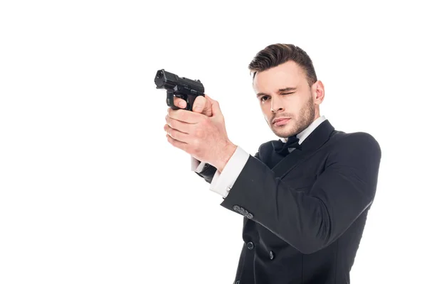 Asesino peligroso en traje negro apuntando con pistola, aislado en blanco - foto de stock