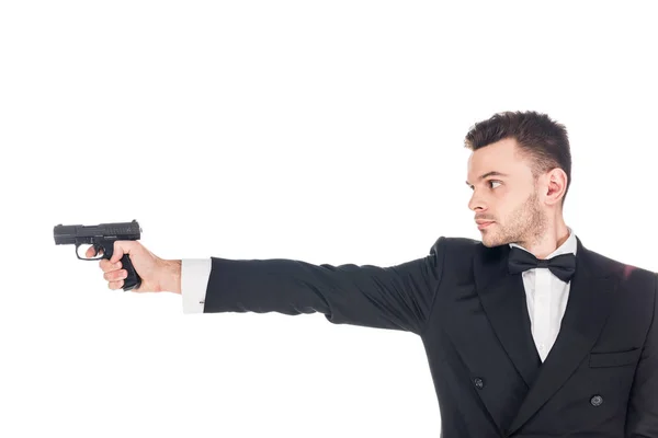 Peligroso agente secreto en traje negro apuntando con pistola, aislado en blanco - foto de stock