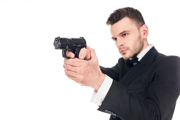 Guapo asesino serio en traje negro apuntando con pistola, aislado en blanco - foto de stock