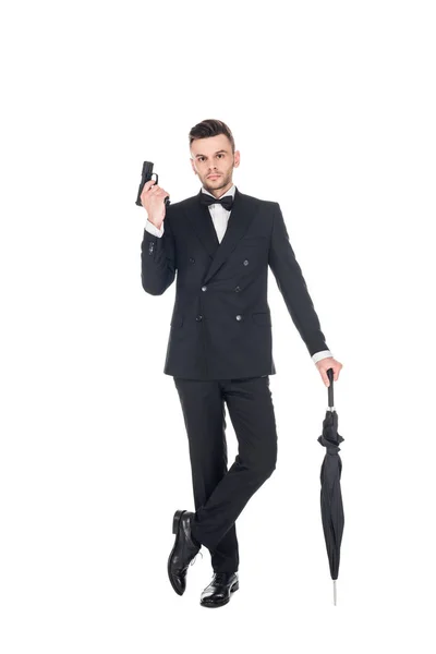 Handsome killer in tuxedo holding handgun and umbrella, isolated on white — Stock Photo