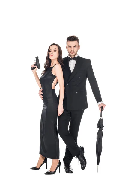 Красива пара вбивць в чорному одязі тримає пістолет і парасольку, ізольовані на білому — стокове фото