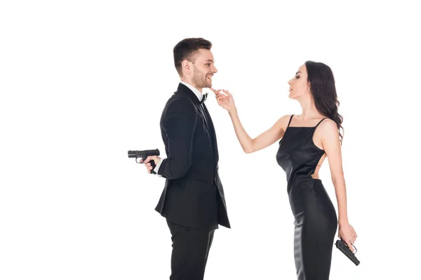 Together couple of secret agents in black clothes holding guns, isolated on white — Stock Photo