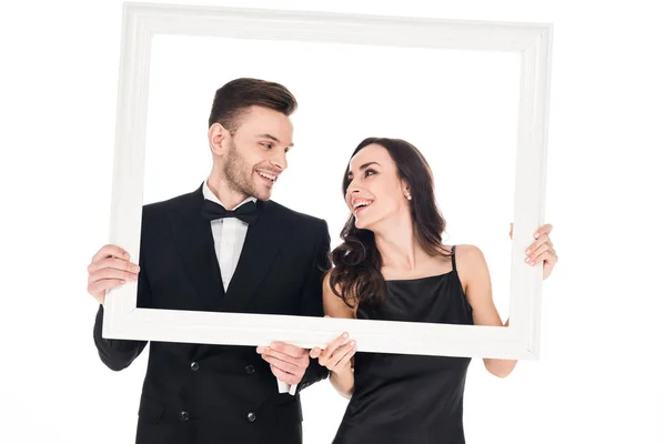 Cheerful couple in black clothes posing with frame, isolated on white — Stock Photo