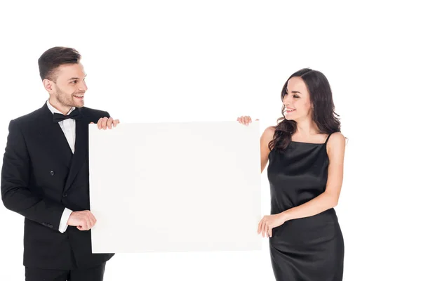 Attractive couple in black elegant clothes holding empty board, isolated on white — Stock Photo